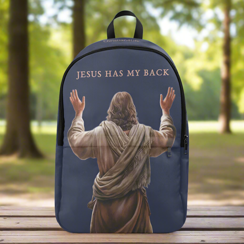Backpack with 'Jesus Has My Back' text and image of Jesus on a wooden bench in a park.
