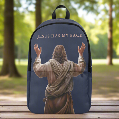 Backpack with 'Jesus Has My Back' text and image of Jesus on a wooden bench in a park.