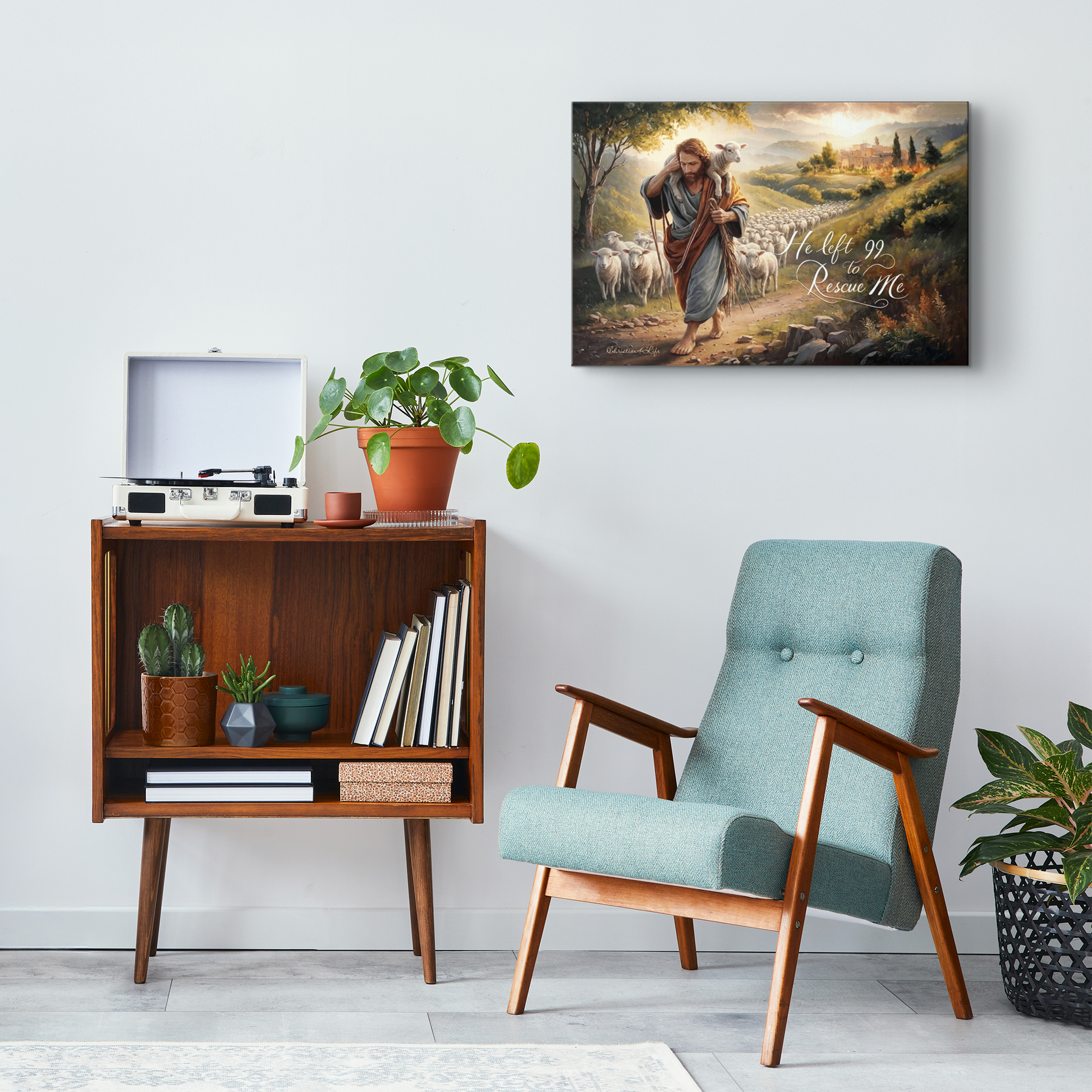 Room interior with a teal armchair, wooden side table, and wall art of a shepherd with sheep.