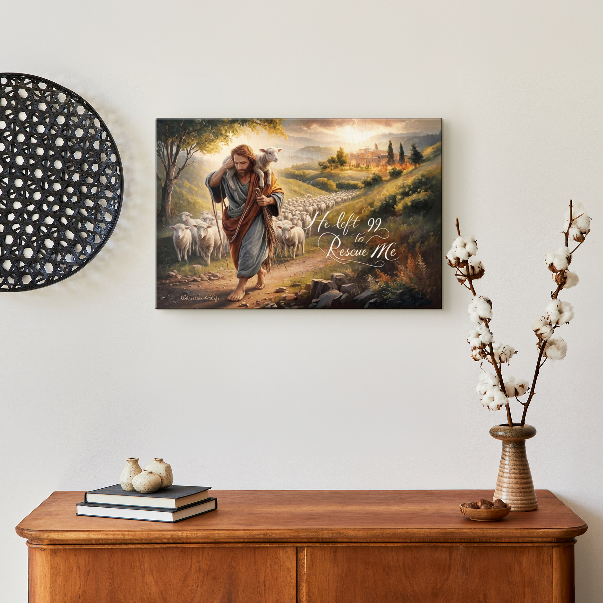 Framed artwork of a shepherd with sheep on a wall above a wooden cabinet.