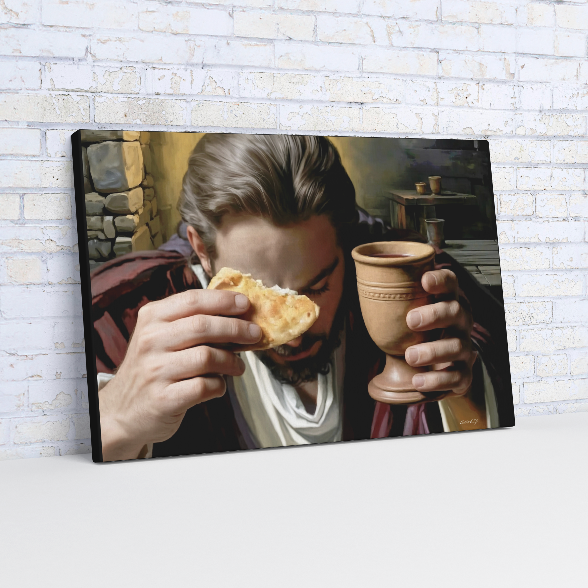 Framed artwork of Last Supper scene with Jesus sharing bread and holding a cup with wine against a brick wall.