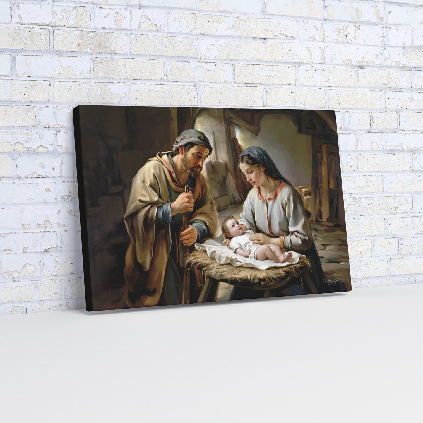 Painting of baby Jesus, Joseph and Mary  on a wooden shelf against a white brick wall.