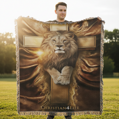Person holding a blanket with a lion and cross design outdoors