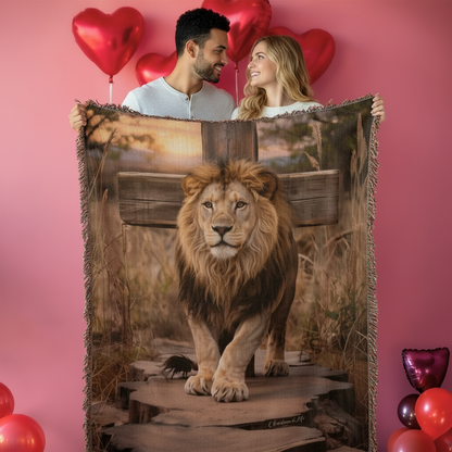 Couple holding a blanket with a lion design against a pink background with heart balloons.